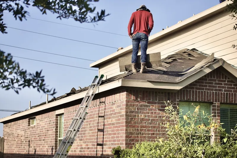 Professional roofer working on a residential roof in Mozart